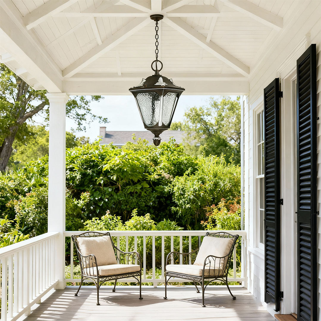 Classic outdoor porch pendant light brightening white covered deck with railing and outdoor furniture