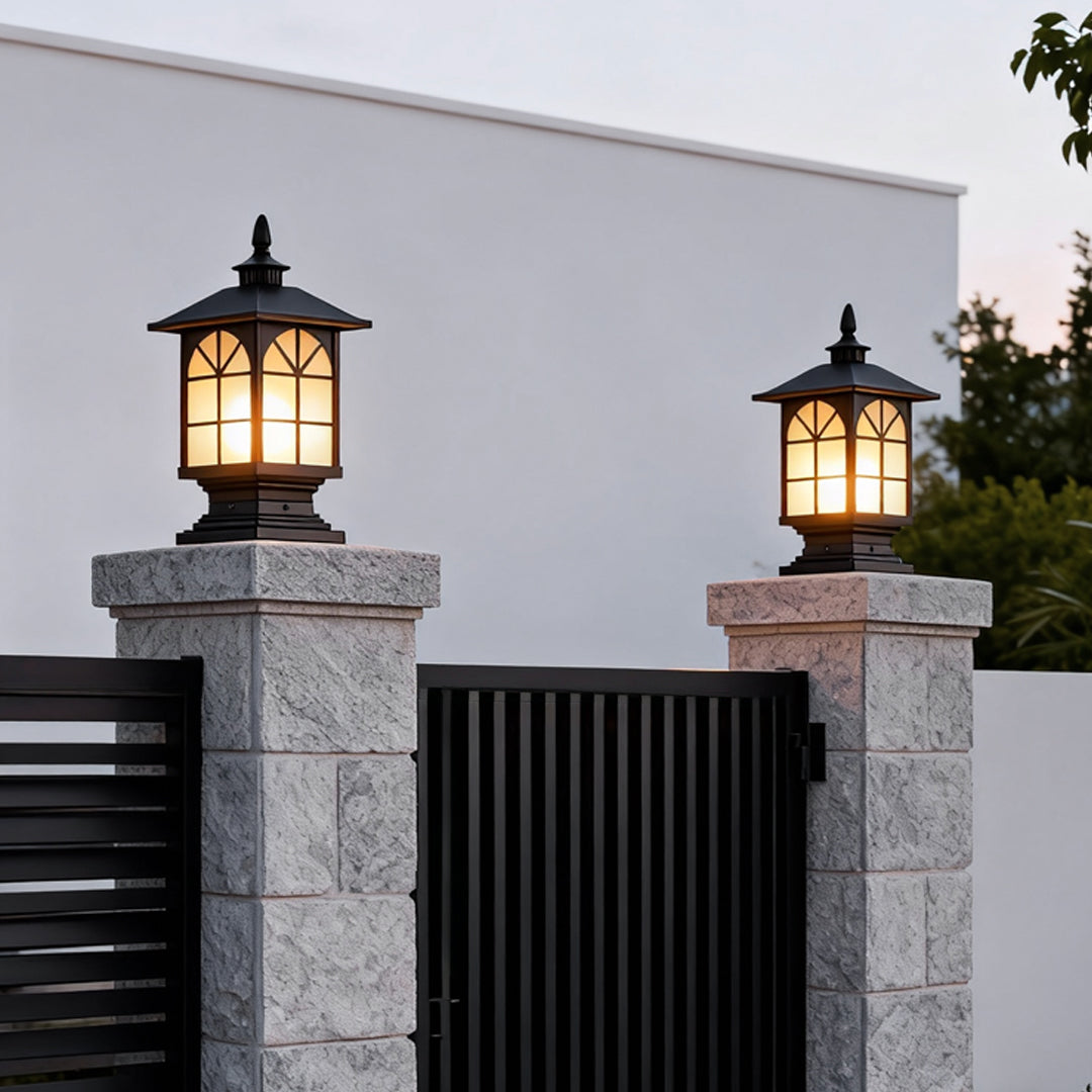 Classic outdoor street light pillar installed on gate posts with warm illumination.