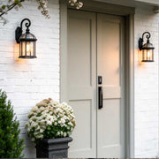 Classic outdoor wall lanterns illuminating a white house entrance with warm vintage glow.