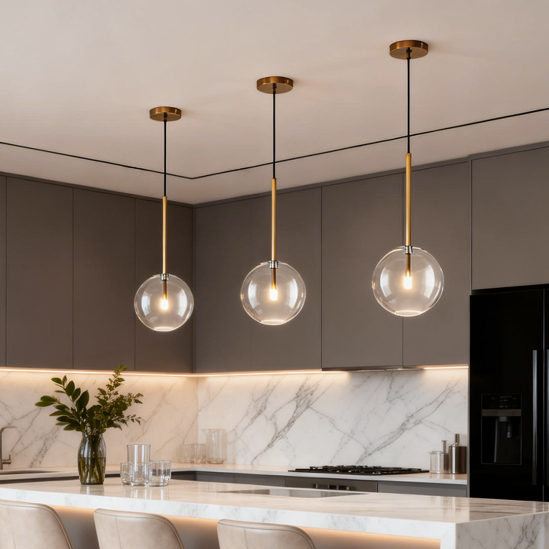 Elegant clear glass globe pendant light with a golden fixture, adding a modern touch to any room. Perfect for dining or living areas.