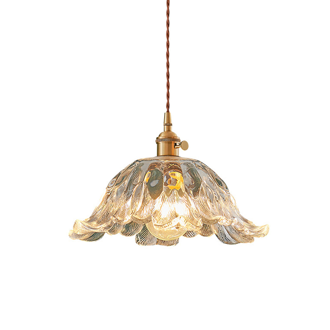 Clear glass flower pendant lighting with petal-inspired design and antique brass ceiling mount.
