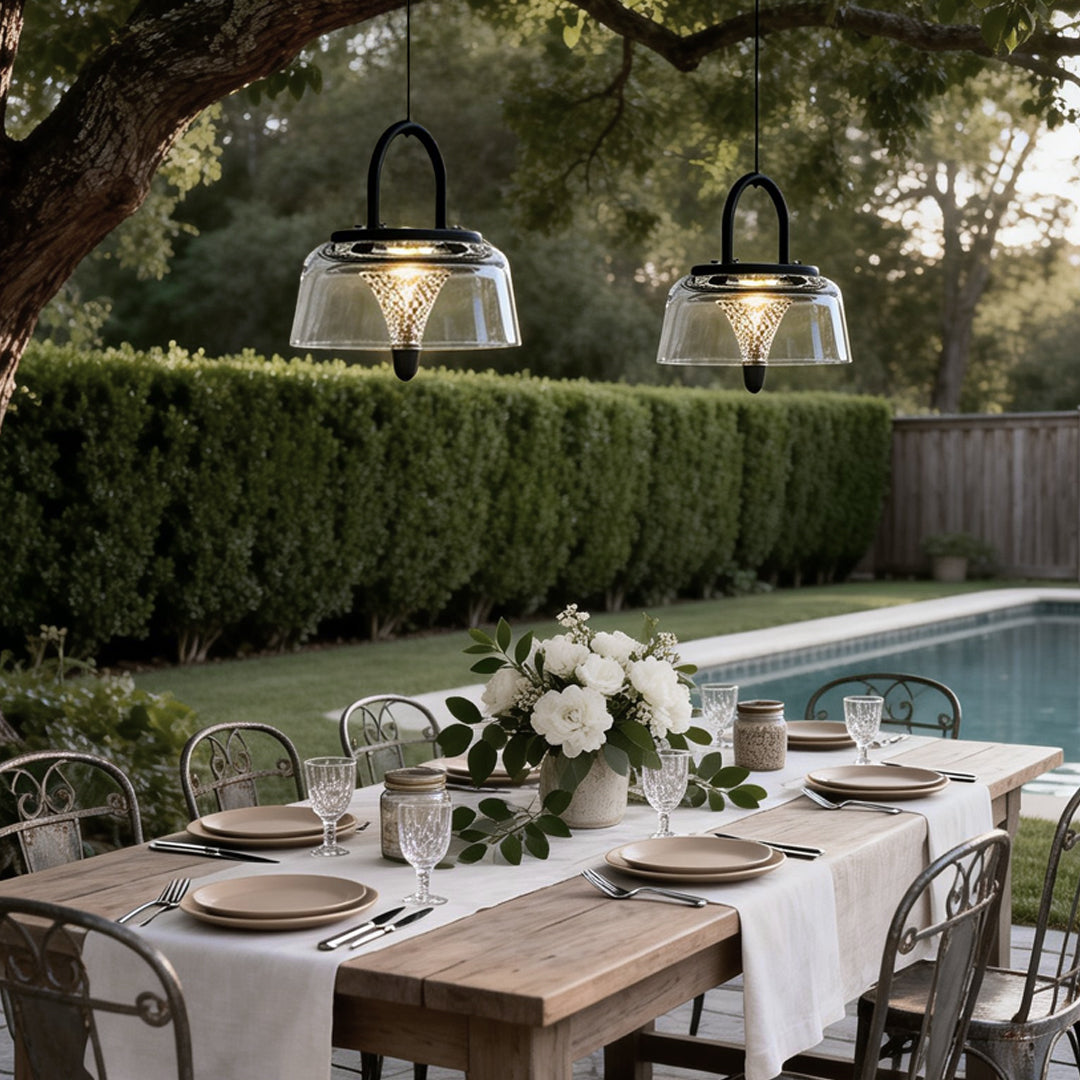 Clear pendant lights illuminating an outdoor dining area, enhancing the evening dining experience.
