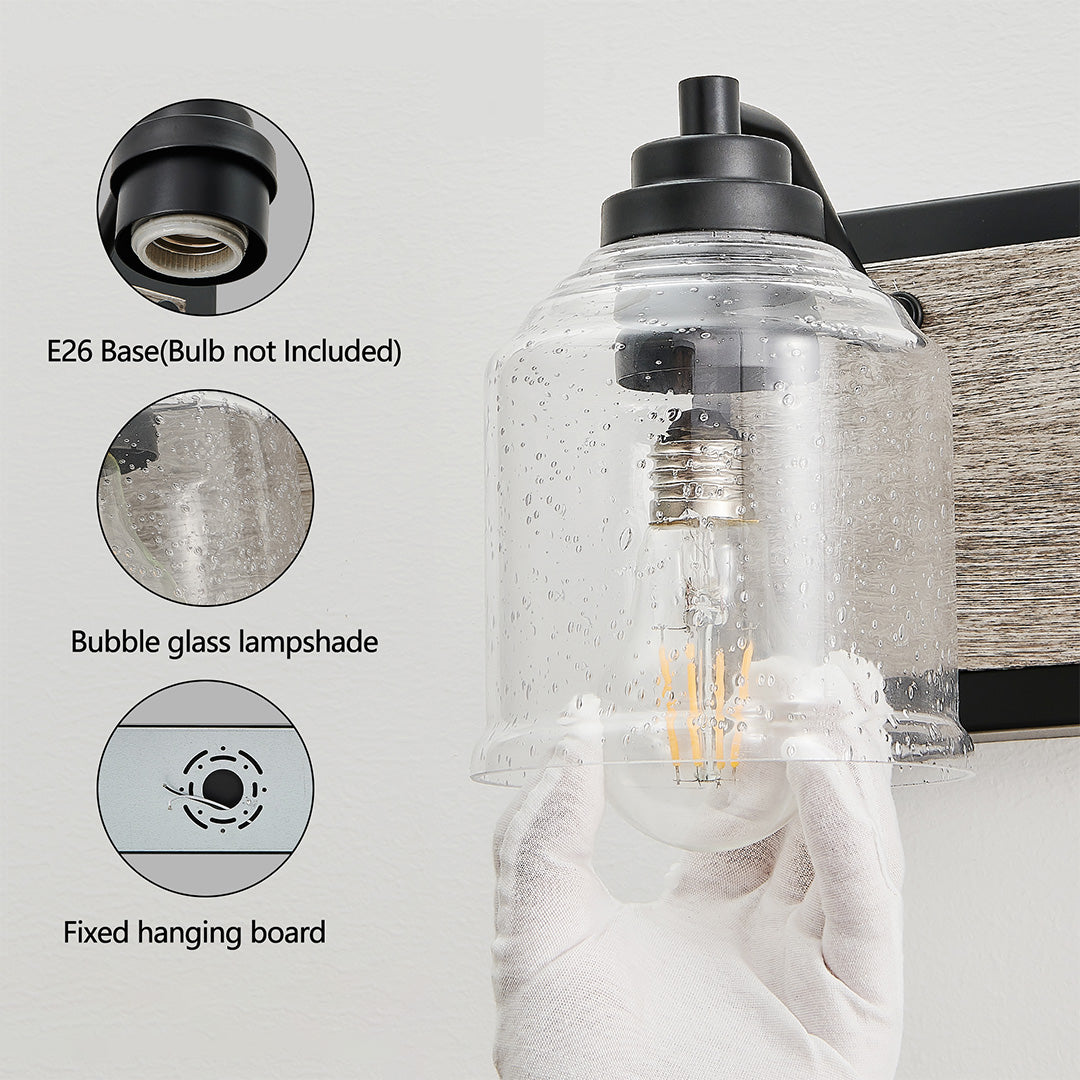 Close-up of a multi-light wall sconce's black metal base and clear glass shades, highlighting its rustic charm.