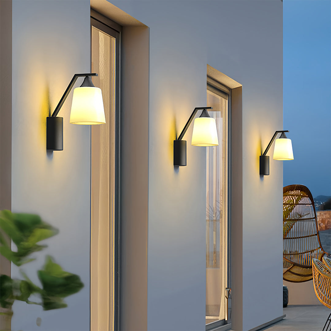 Close-up view of the outdoor black sconce, showcasing its unique design with a white shade for warm illumination.