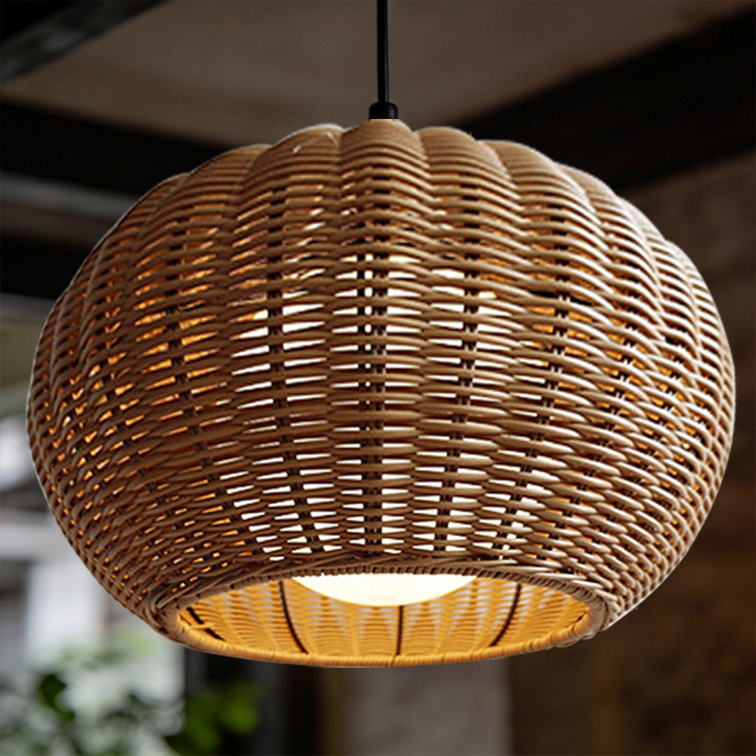 Close up detail of a brown rattan outdoor pendant light shade with a warm bulb glowing inside.