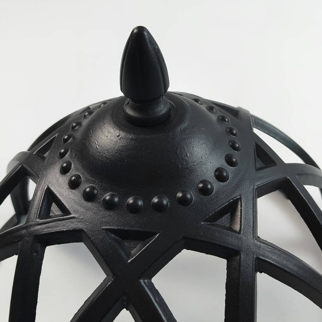 Close-up of the cage structure and top finial on a vintage black globe pillar light fixture ok.
