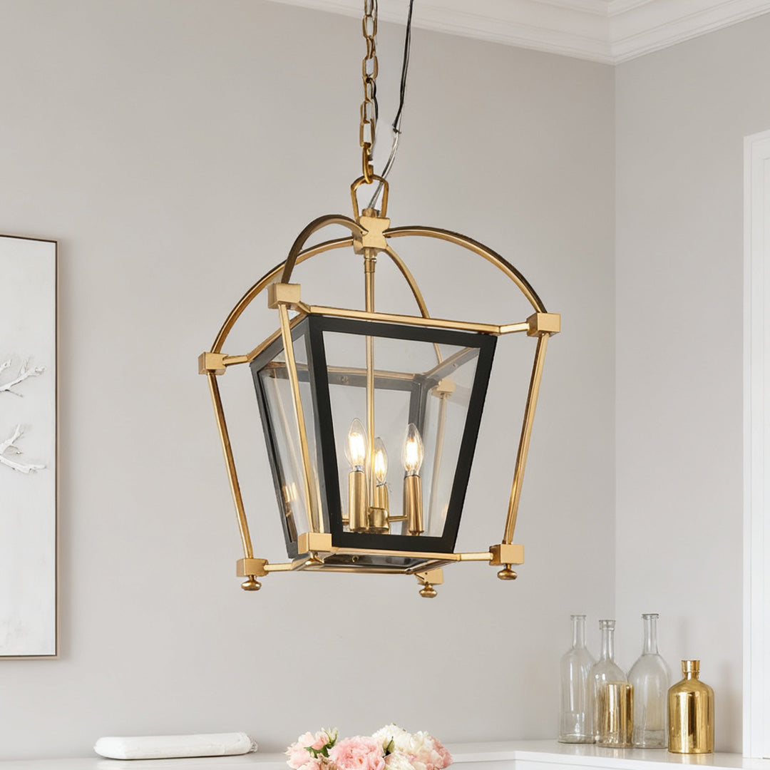 Close-up view of the classic square-shaped gold lantern pendant light, highlighting the sleek brass frame and clear glass panels.