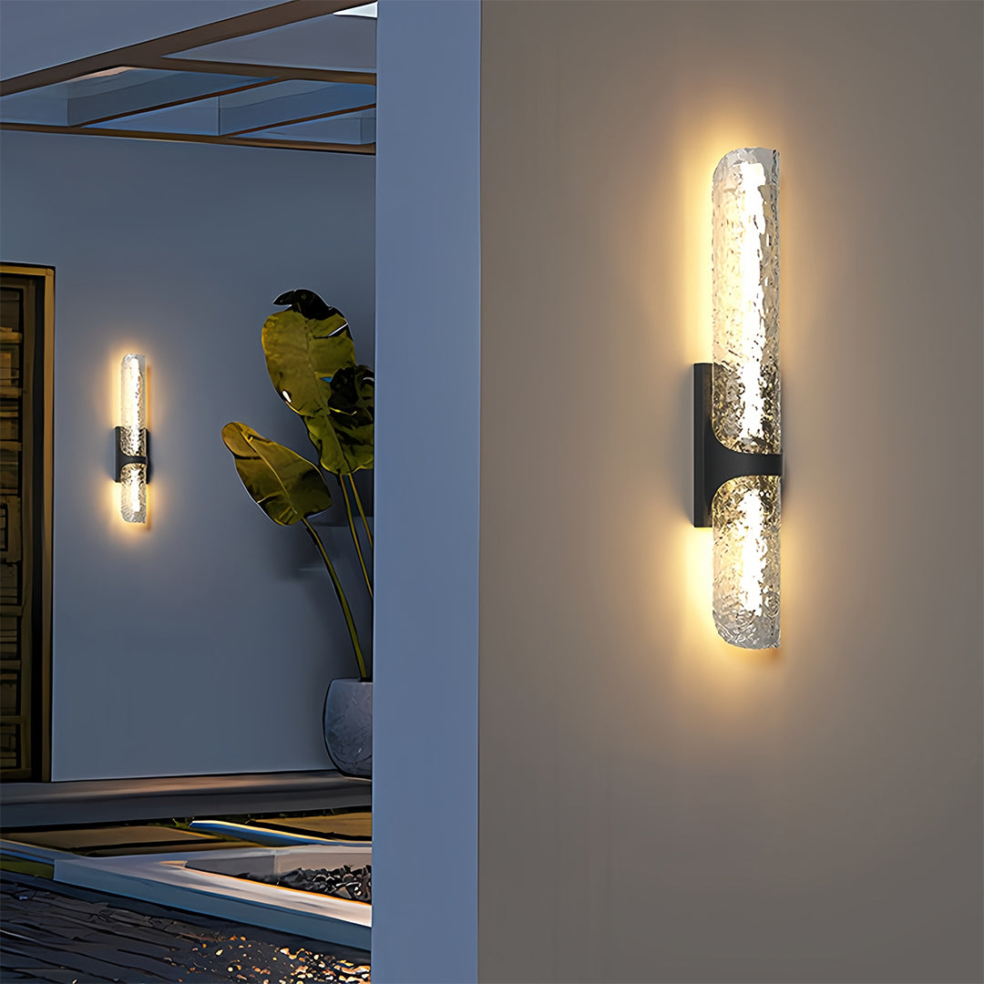 Close-up view of contemporary black outdoor wall lights providing ambient illumination on a smooth exterior wall.