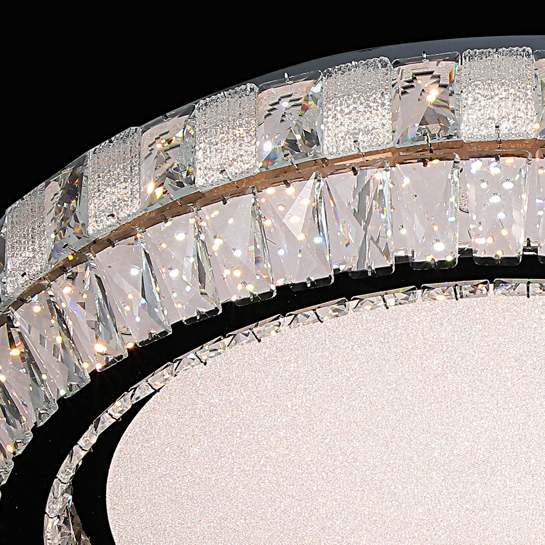 Close-up of a contemporary flush mount light, highlighting the crystal details and metallic frame.