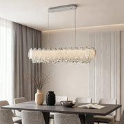 Close-up of French country chandelier showing leaf-shaped crystals and gold accents.