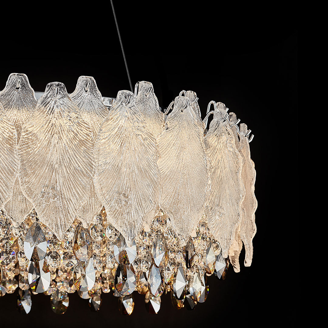 Close-up of French country chandelier showing leaf-shaped crystals and gold accents.