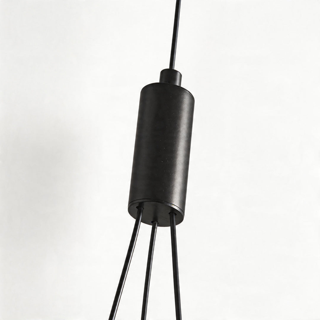 Close up detail of the black cylindrical hardware and wires of a globe pendant light fixture ok
