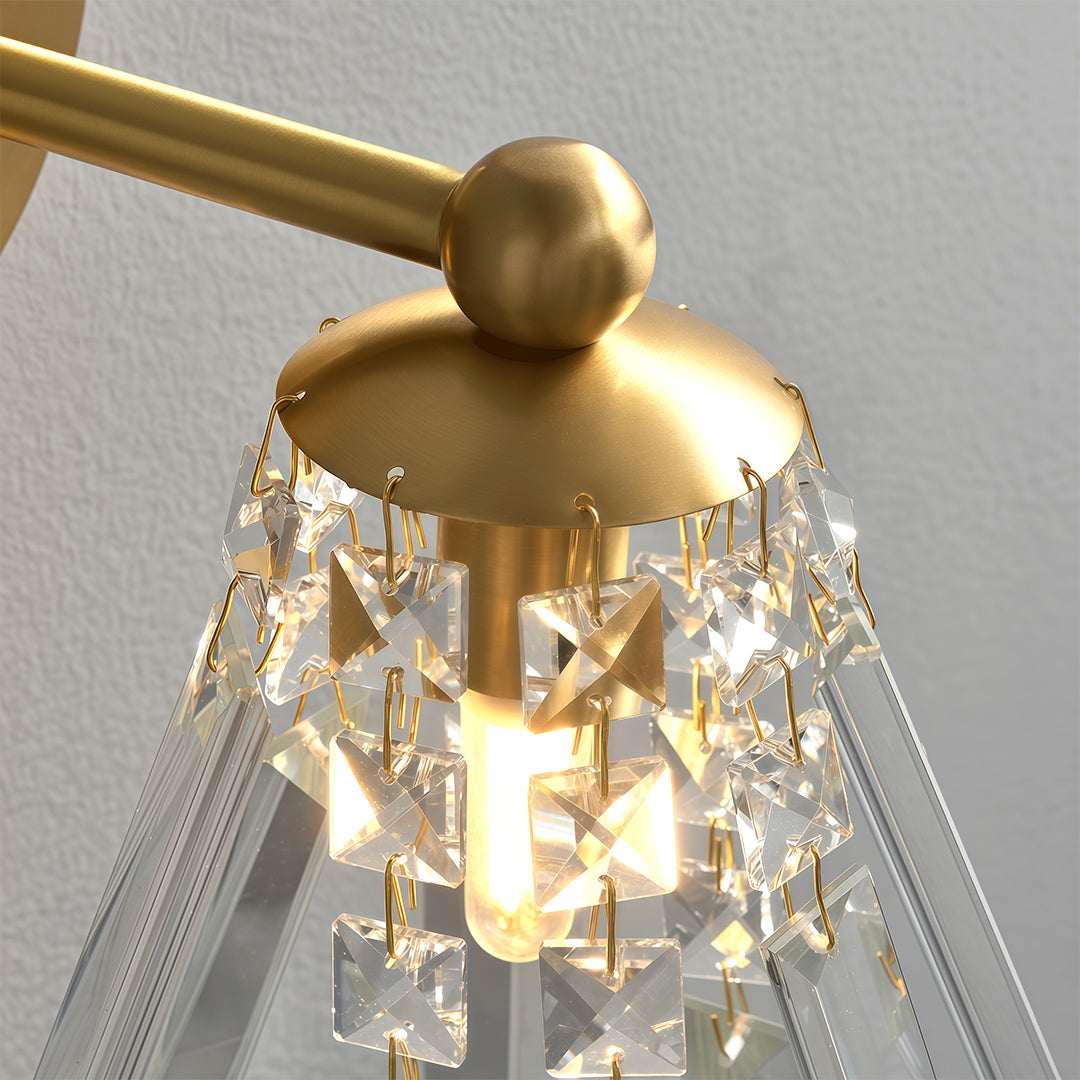 Close up detail of crystal wall lights featuring glass shade chandelier styling highlighting brushed gold construction and crystal bead detail.
