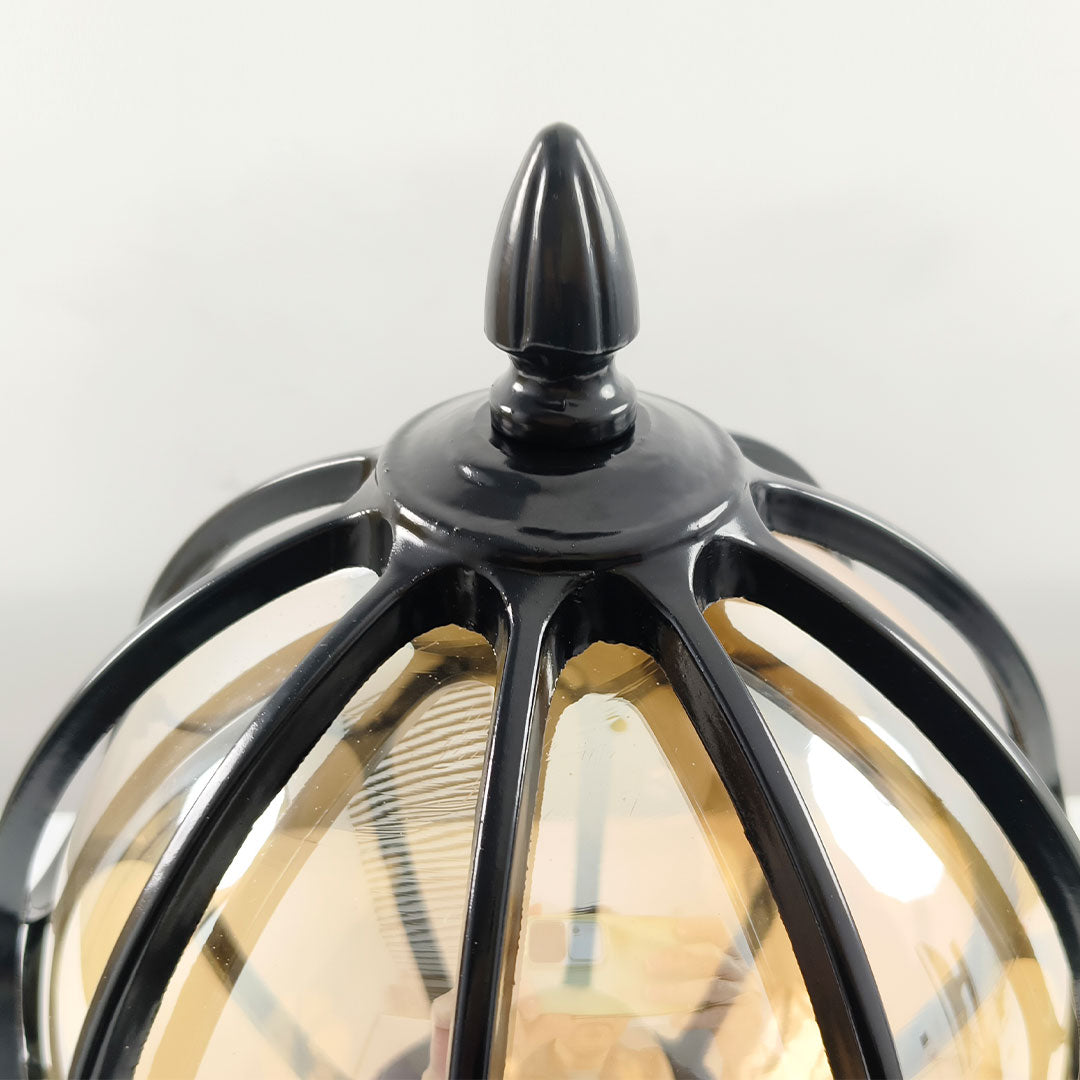 Close-up of the elegant pointed top finial of a black vintage outdoor globe pillar light now!!