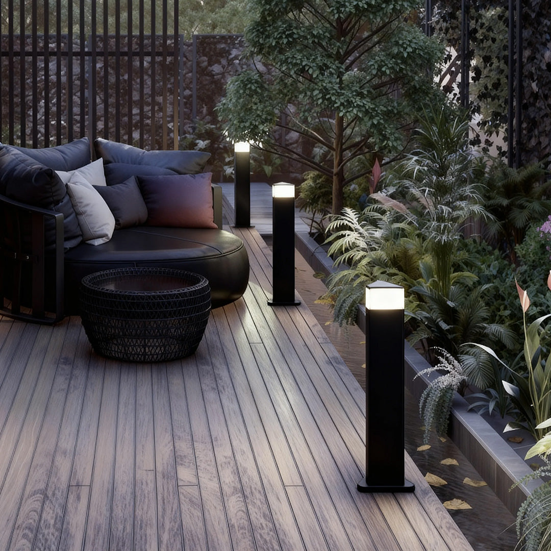 Close-up of an exterior pathway light, highlighting the black finish and warm light source.