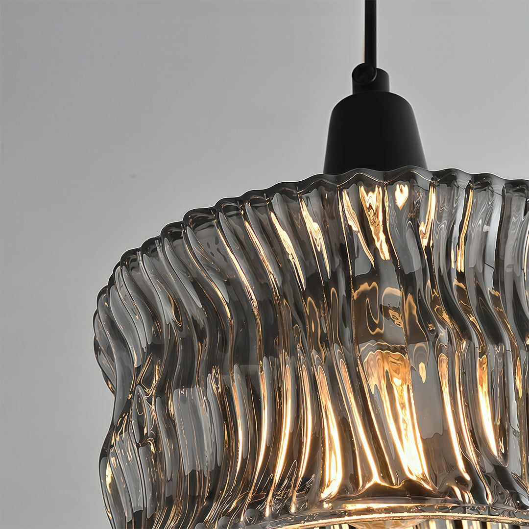 Close-up of the top of a glass drum pendant light, emphasizing the black metal frame and design.