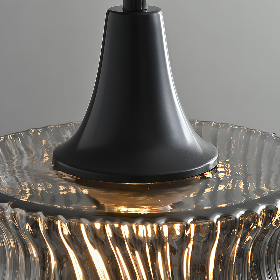 Close-up of the top of a glass drum pendant light, emphasizing the black metal frame and design.