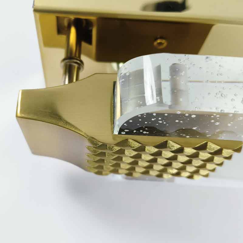 Extreme close-up of the bubble crystal and gold grid pattern on a luxury modern wall light.