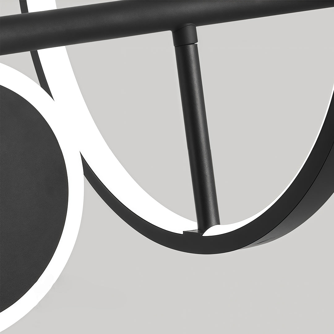 Close-up detail of the illuminated white rings and matte black finish on the modern 6 light chandelier fixture.