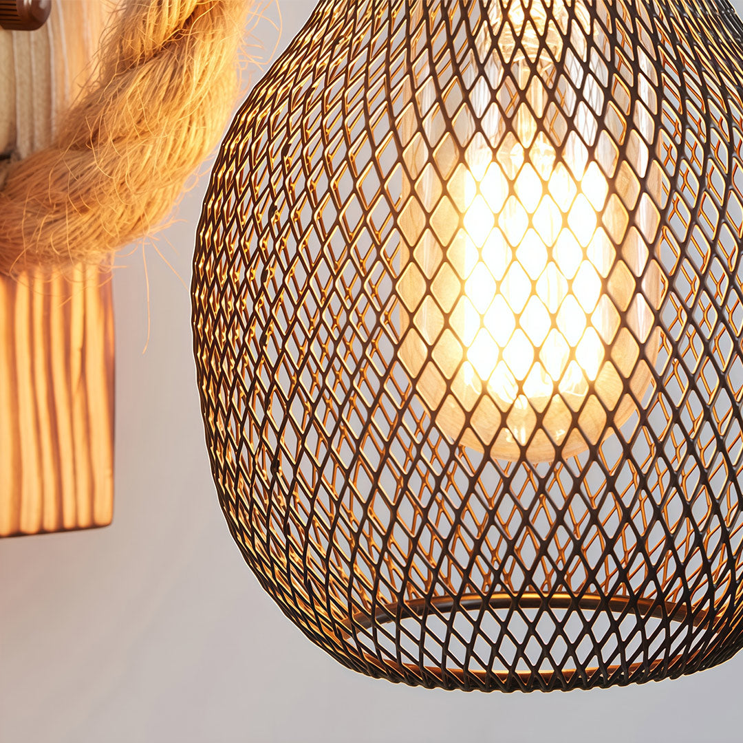 Close-up of the metal mesh cage and illuminated filament bulb of the rustic wall light, showcasing the wire wrap.