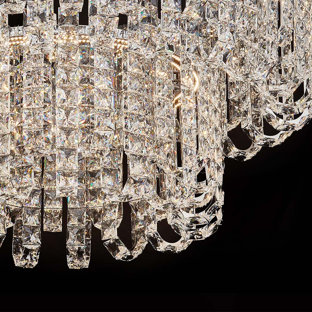 Close-up of faceted glass and metal details on luxury modern crystal chandelier.