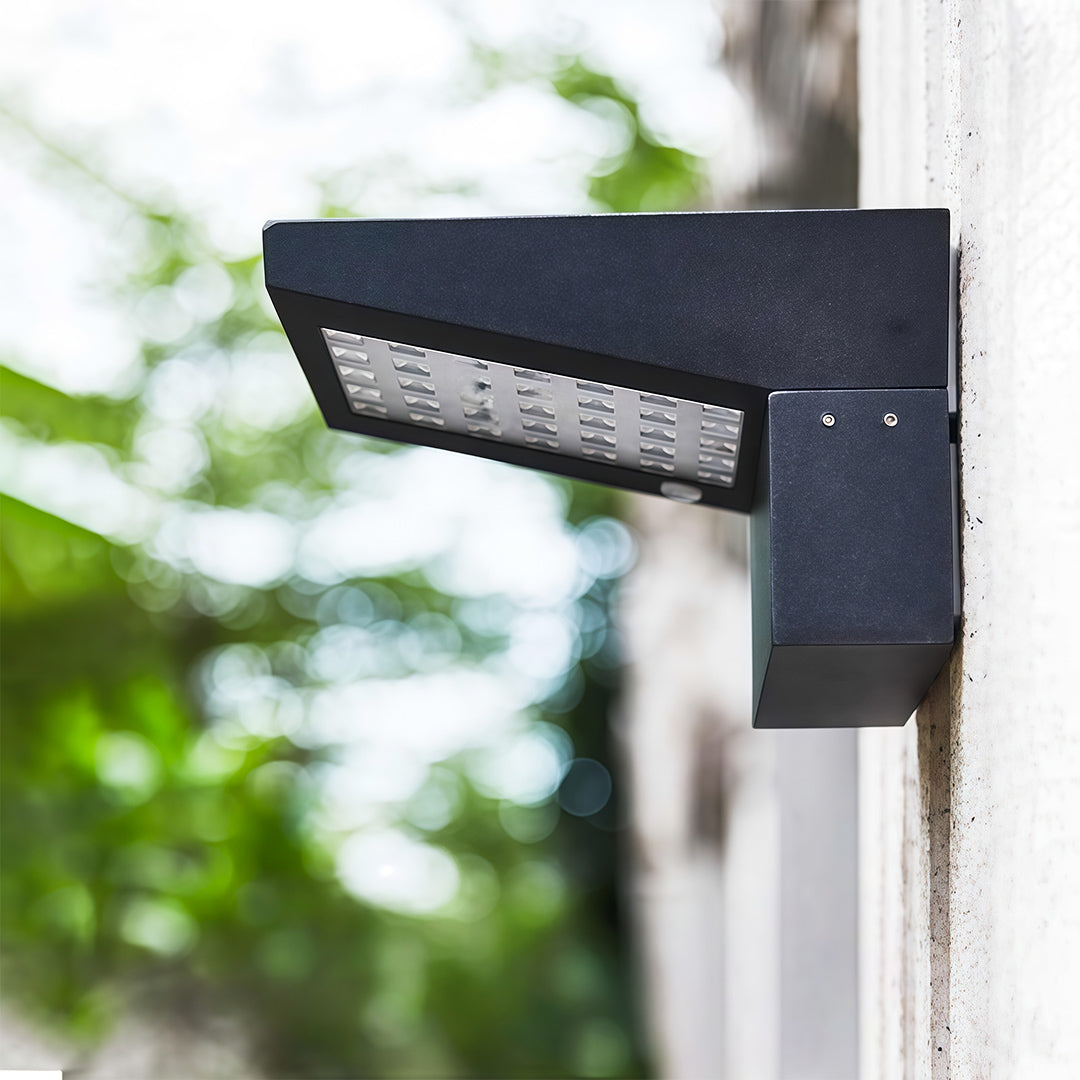Close-up view of a modern LED panel wall mount outdoor light fixture in a black finish.