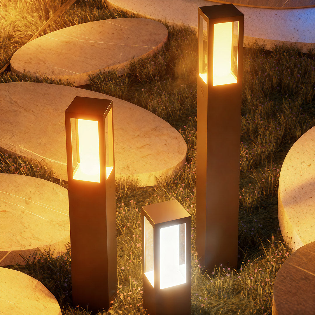 Close-up of an outdoor bollard light, highlighting the black finish and warm light source.