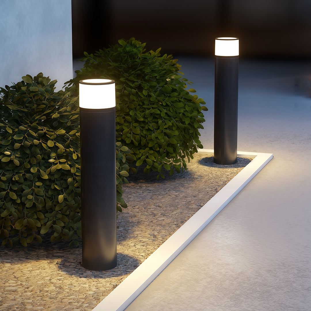 Close-up of an outdoor path light, highlighting the black finish and warm light source.