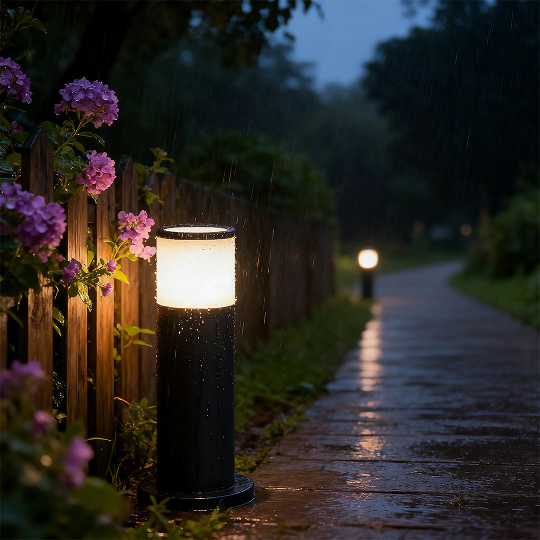Close-up of an outdoor path light, highlighting the black finish and warm light source.