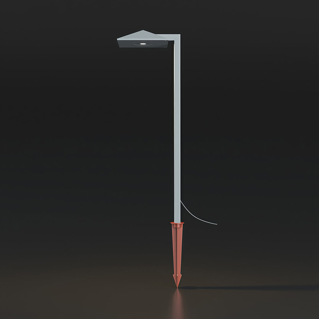 Close-up of an outdoor pathway light, highlighting the metallic finish and flat top light source.