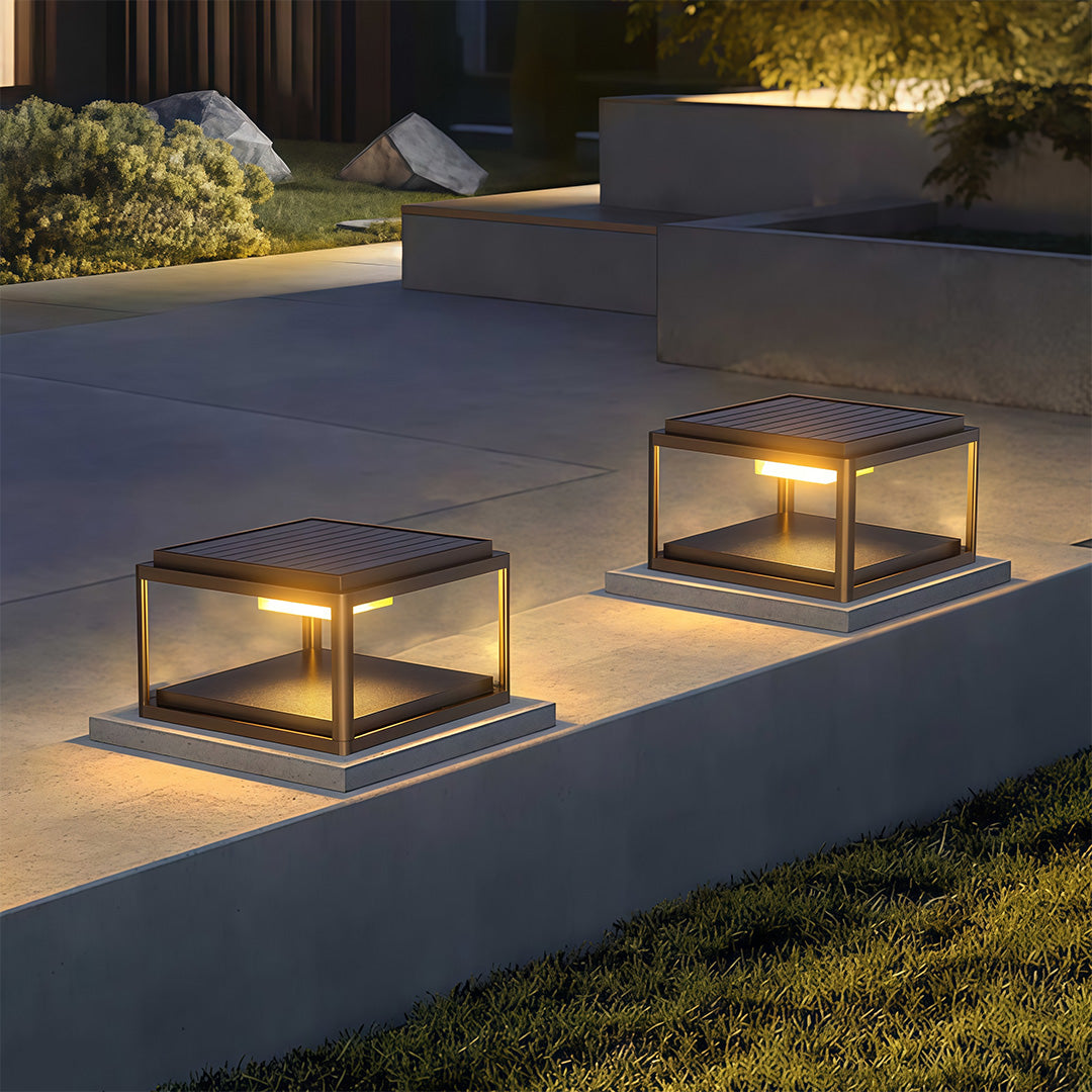 Close-up of a pillar gate light, highlighting the black frame and warm light diffusion.