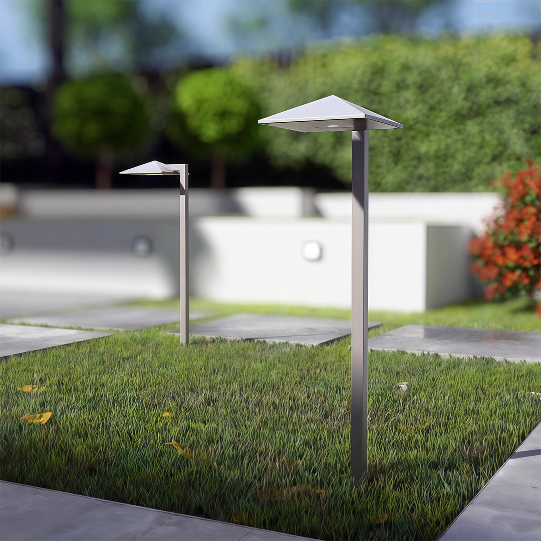 Close-up of a plug-in pathway light, highlighting the metallic finish and flat top light source.
