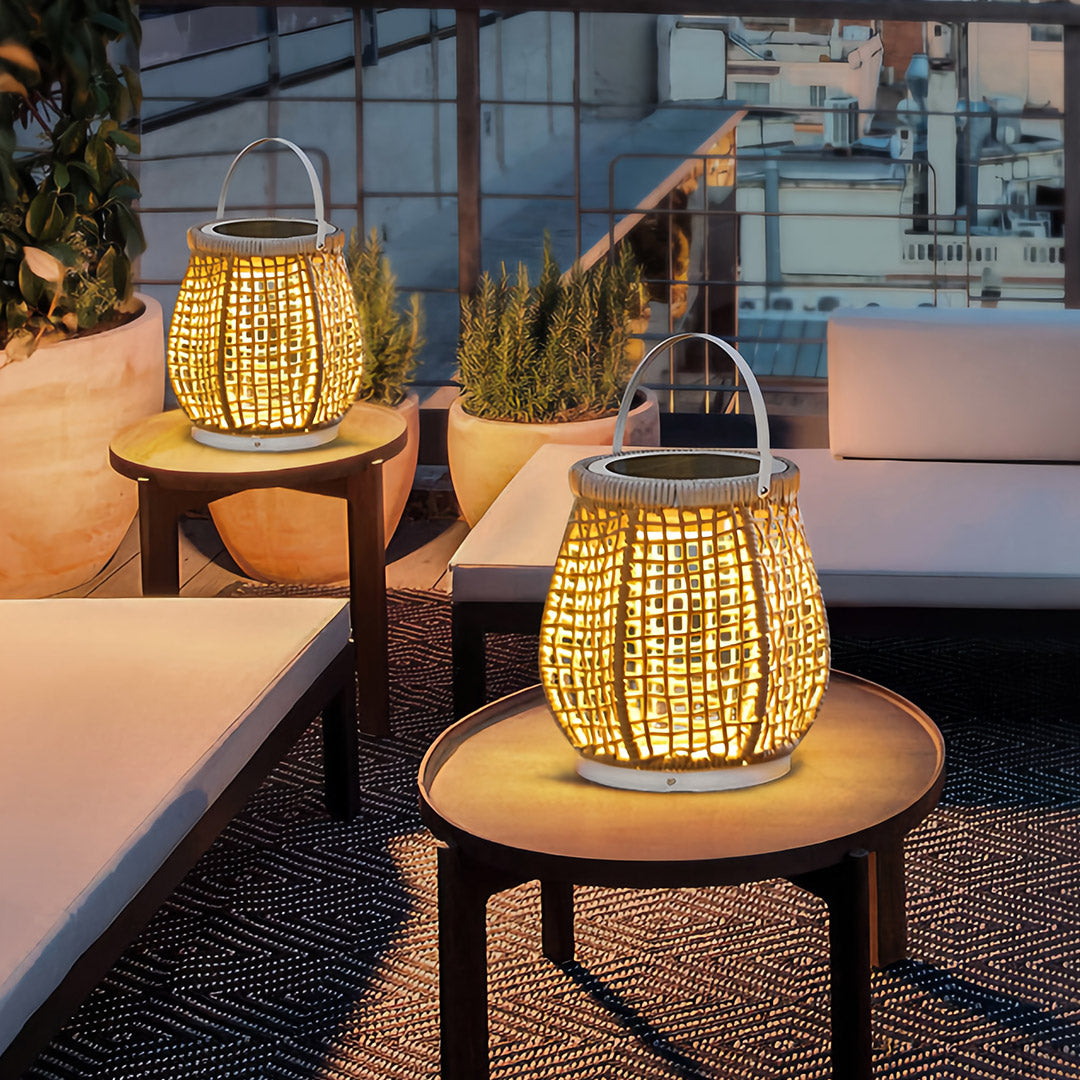 Close-up of a woven outdoor lanterns used as accent lighting on a side table on a deck, highlighting the intricate rattan-like texture and warm glow.