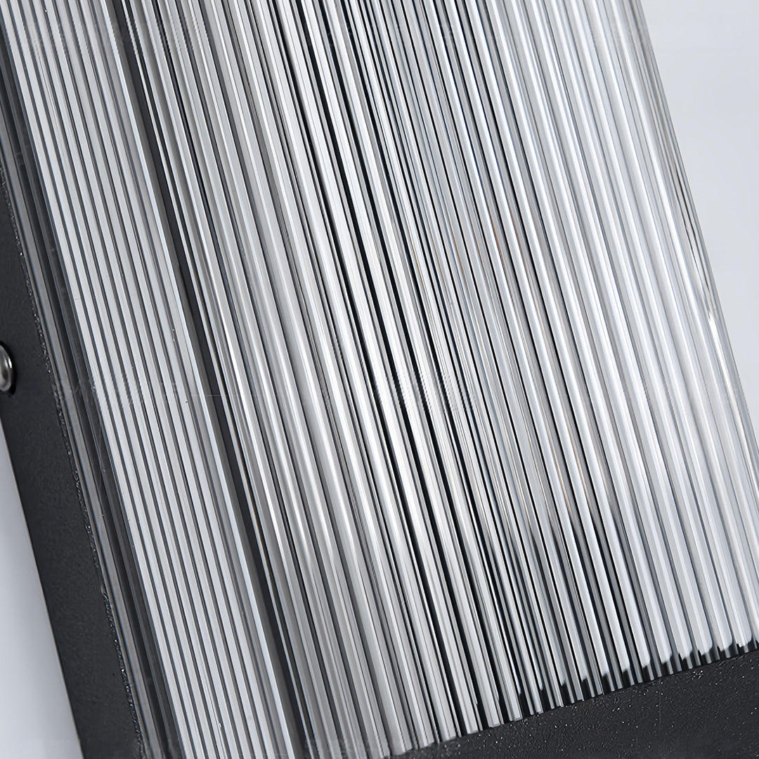 Close-up detail of the vertically ribbed glass diffuser on a modern linear outdoor sconce.