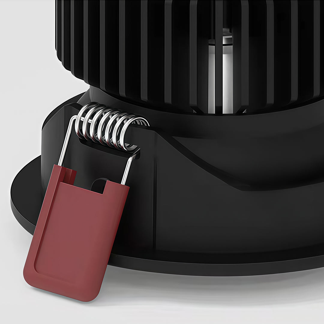 Detailed close-up of the spring mounting clip and large heat sink on a black modern spotlights fixture.