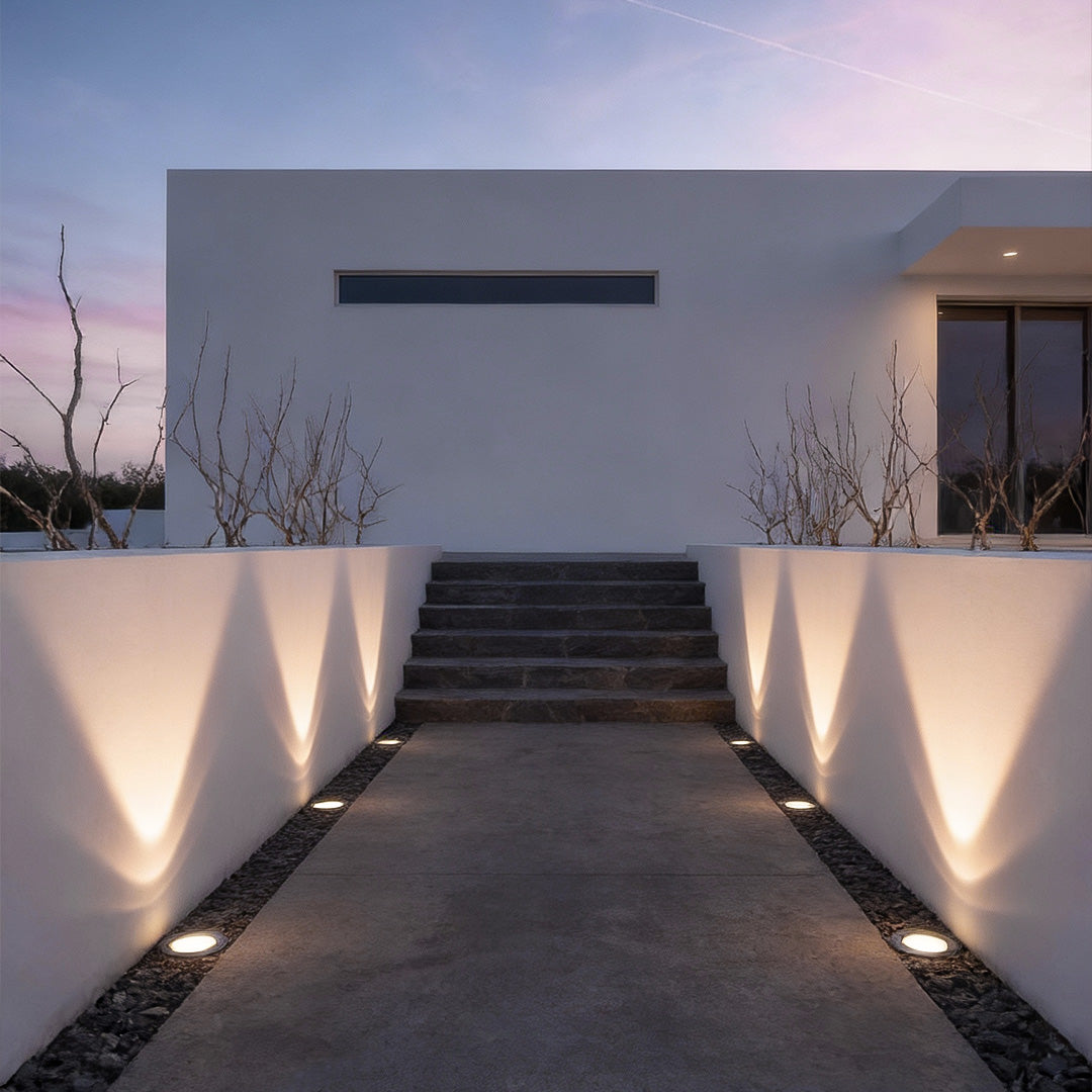 Close-up of recessed floor lighting fixture with stainless steel rim and solar panel for garden use.