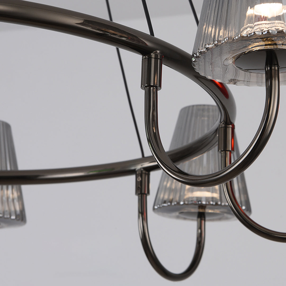 Close-up detail of chandelier arm connection showing decorative metalwork and glass shade mounting