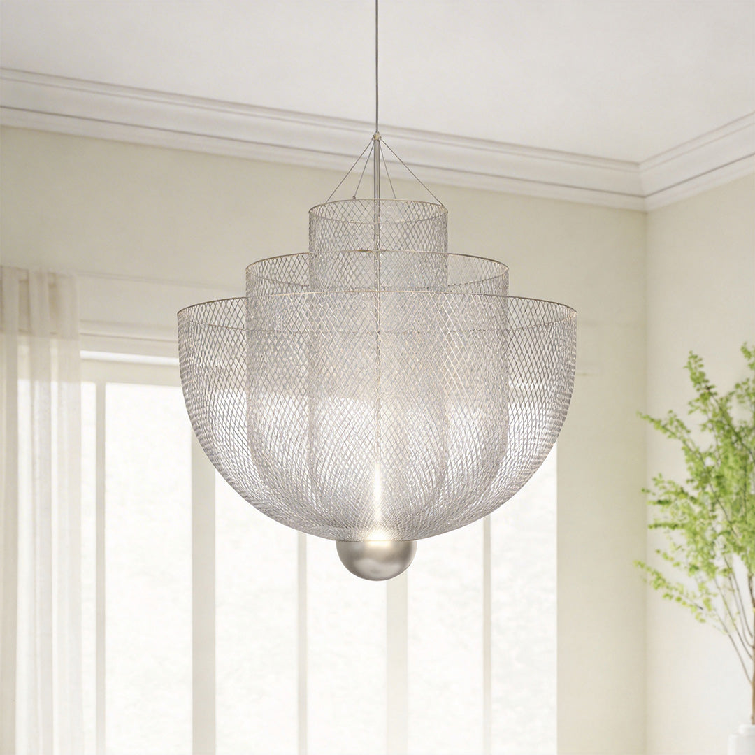 Close-up of a tiered silver mesh chandelier with draped metal chains in a bright luxury room.