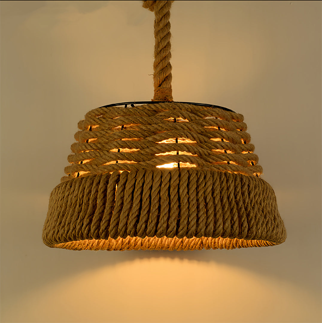 Close up of a tightly woven natural jute rope pendant lights providing a downward, warm-toned light.