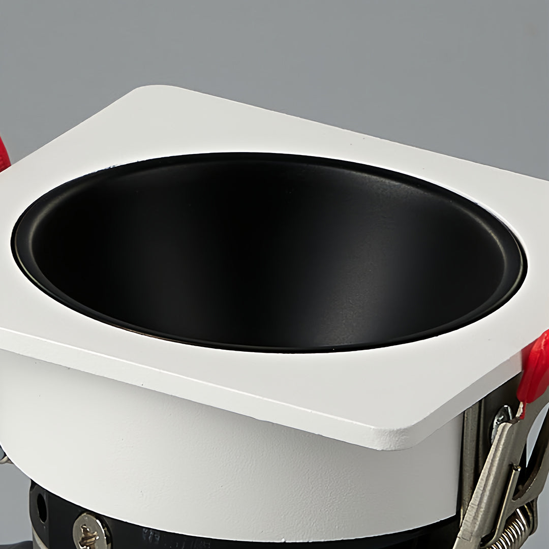 Close-up of triple square recessed downlight with black interior and white frame