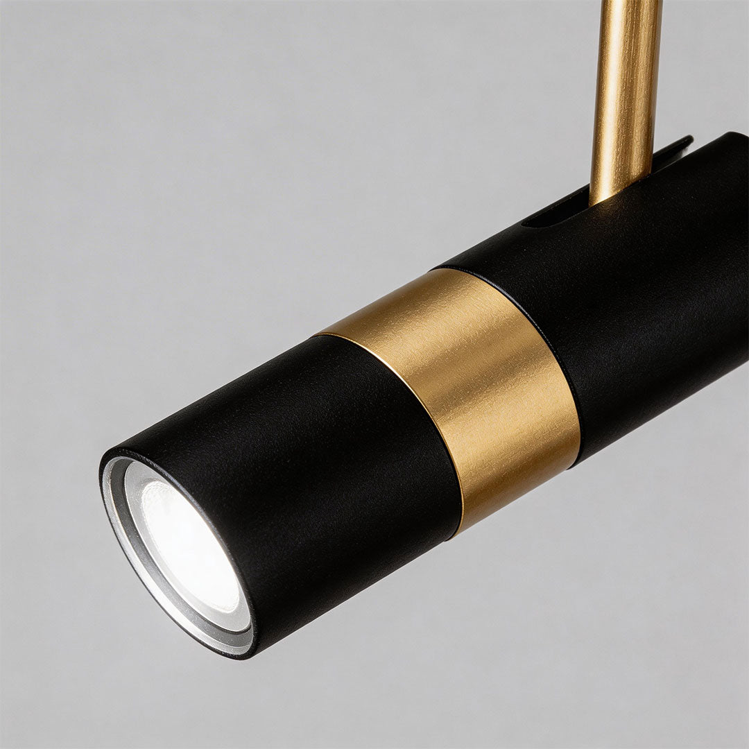 Close-up view of the black gold adjustable cylindrical pendant light showing textures and lens.