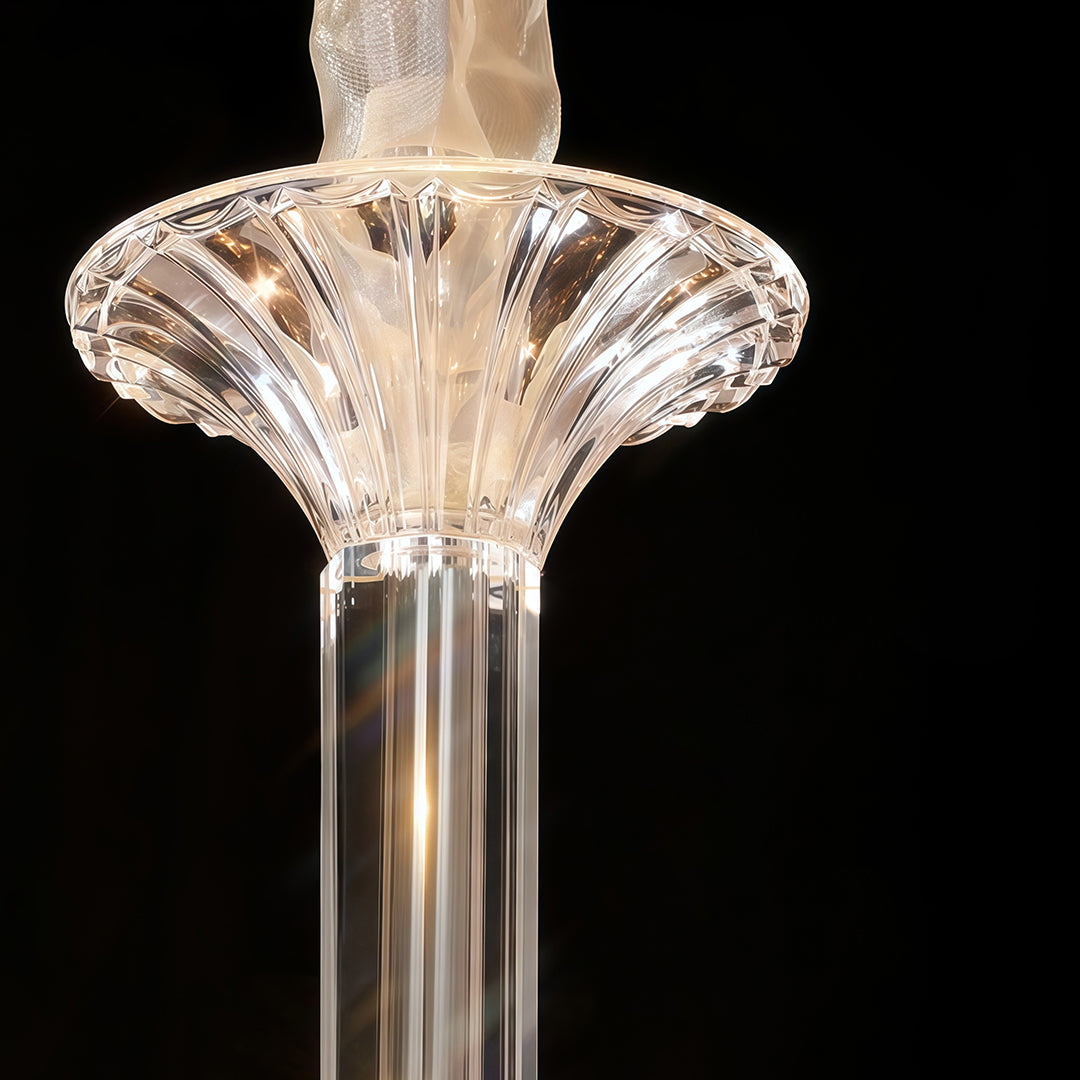 Close-up of art glass chandelier center column with decorative crystal fan-shaped topper on black.