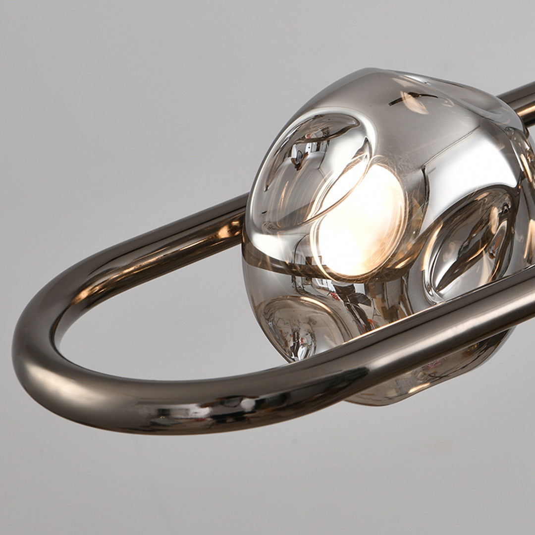 Close-up detail of rise and fall pendant light showing reflective chrome glass globes and metal framework