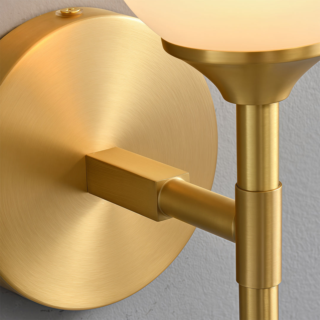 Close-up detail of glass wall lights with glass shade chandelier aesthetic highlighting brass construction and frosted glass detail.