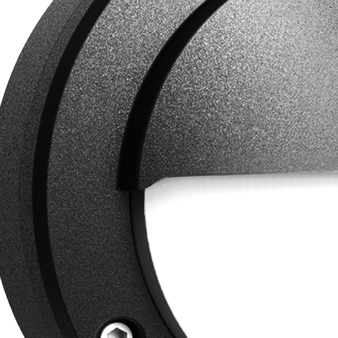 Close-up detail of round outdoor wall sconce displaying textured black finish and hardware