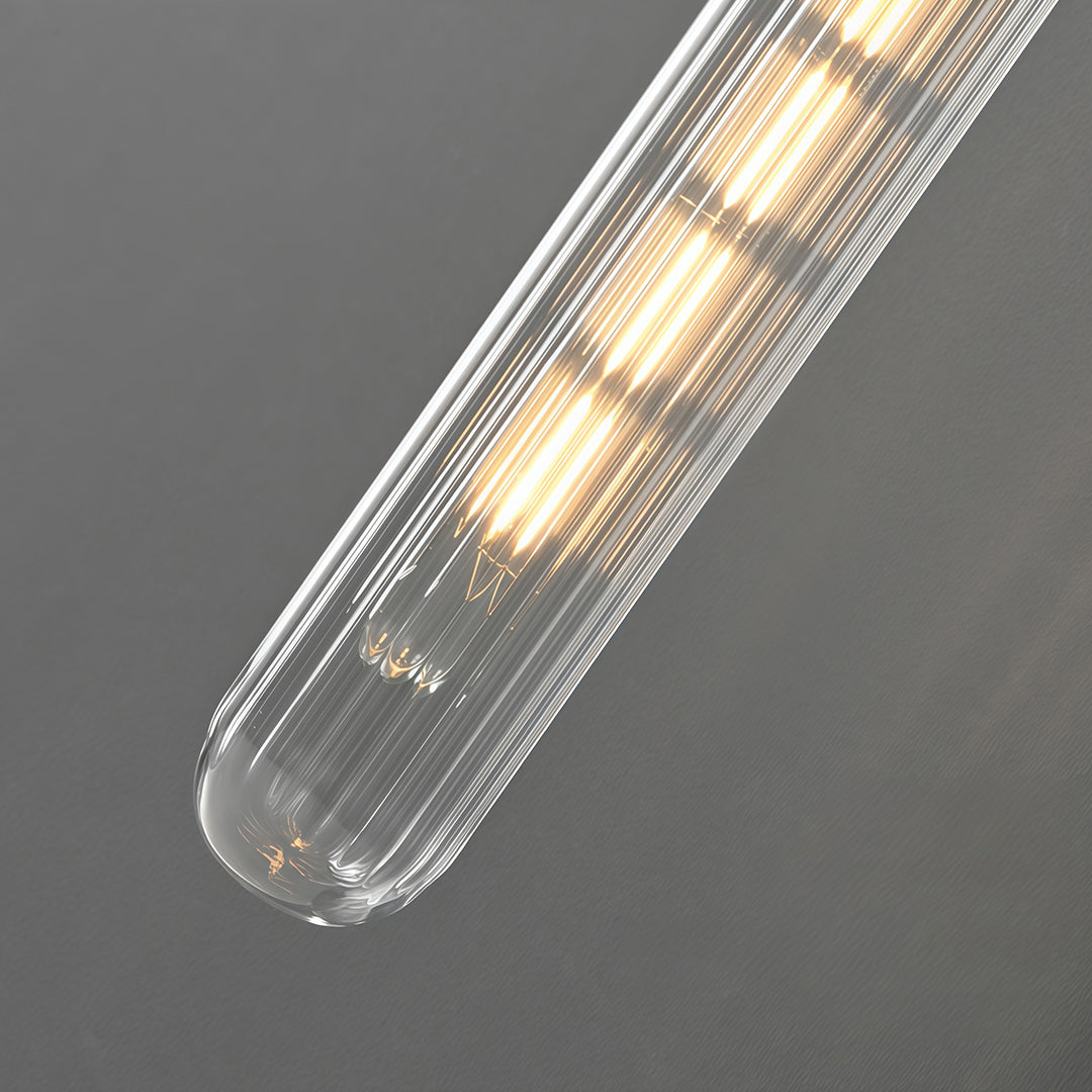 Close-up detail of wall mount pendant light with glass shade chandelier styling showing textured crystal glass tube illuminated.