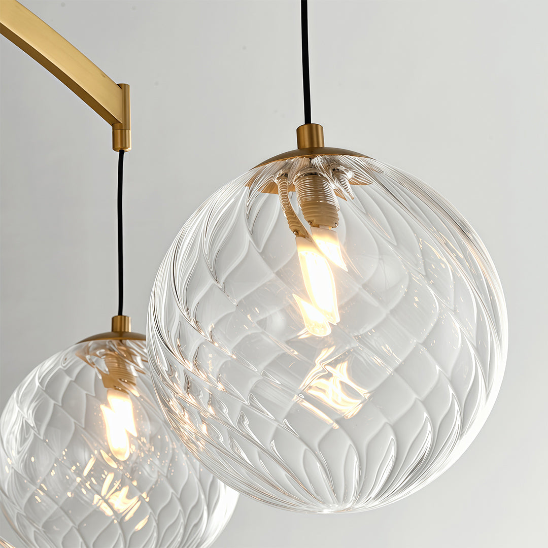 Close-up detail of wall mounted pendant light featuring glass shade chandelier styling showing textured crystal glass sphere illuminated.