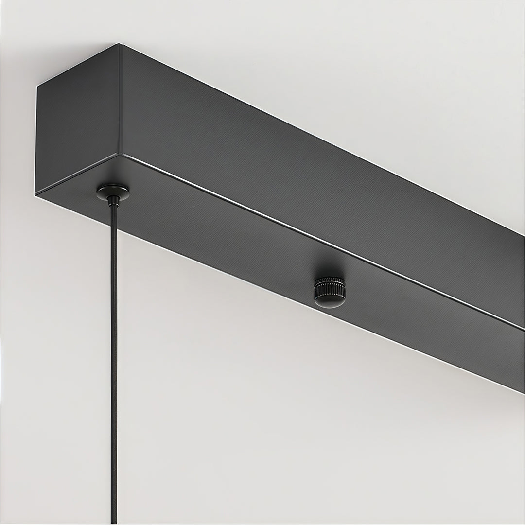 Close-up of gray glass pendant light track system showing black linear mounting hardware and installation detail.