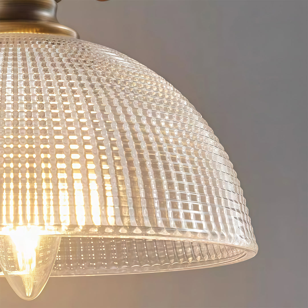 Close-up of indoor wall mount lights featuring glass shade chandelier styling showing detailed prismatic glass texture and brass hardware.