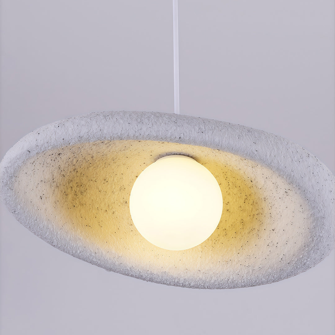 Close-up of Japanese pendant lights featuring glass shade chandelier aesthetic showing detailed textured white disc with warm glow.